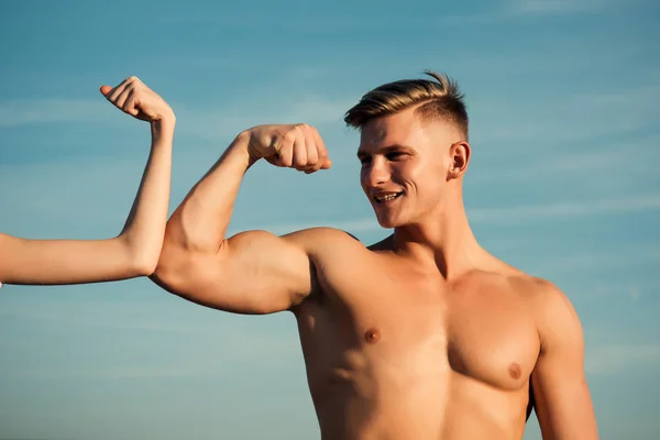 Man met sterke hand biceps, triceps glimlach vrouwelijke dichtbije — Stockfoto