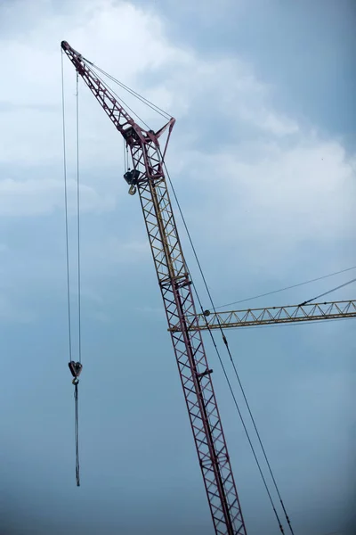 Gru in cantiere su sfondo cielo blu nuvoloso — Foto Stock