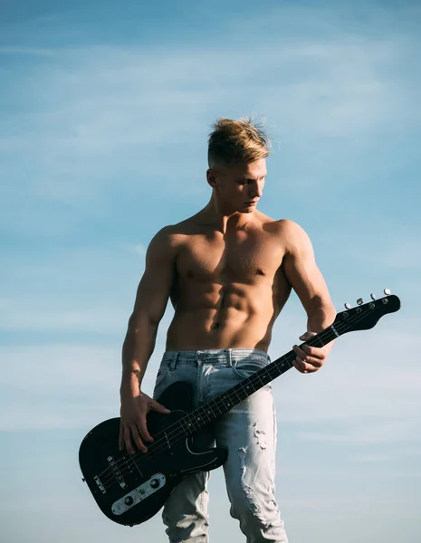 Gitarristen mannen med sex-pack, ab i jeans utomhus — Stockfoto