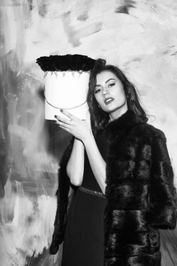 Kırmızı elbise giyen güzel kız kutusunda Güllü poz veriyor