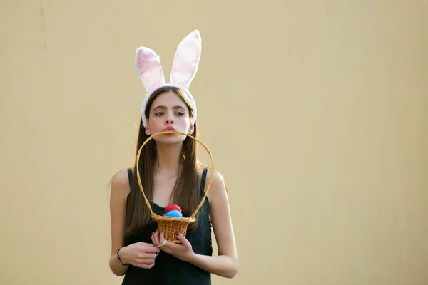 Easter girl with rosy bunny ears on beige background — Stock Photo, Image