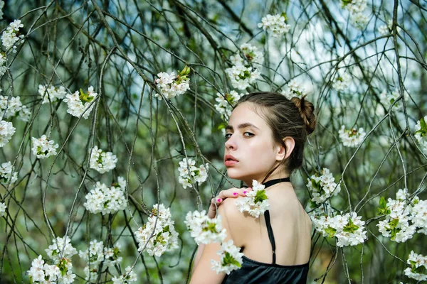 Vrouw poseren in bomen met bloeiende bloemen — Stockfoto
