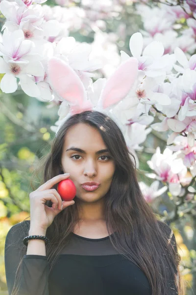 Vrouw met pluche lippen houden rood ei, magnolia — Stockfoto