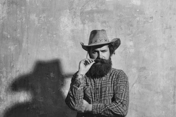 Бородатый мужчина в ковбойской шляпе и черной тени на стене — стоковое фото