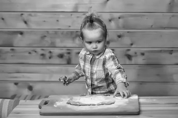 Criança bonito cozinhar com massa e farinha, mantém o molde metálico — Fotografia de Stock