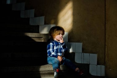 Yürümeye başlayan çocuk düşünme yüzü ile ev merdivenlerde otur