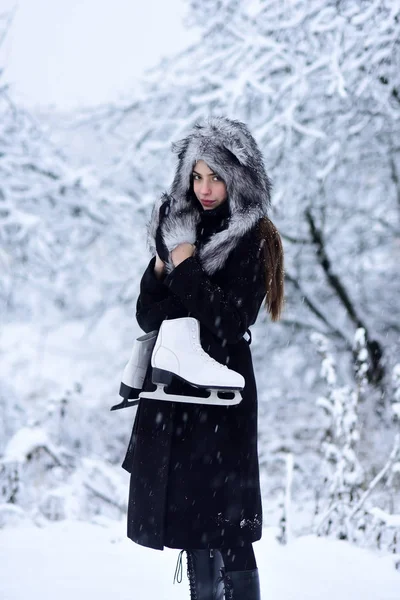 Дівчина з парою фігурних ковзанів на деревах у снігу — стокове фото