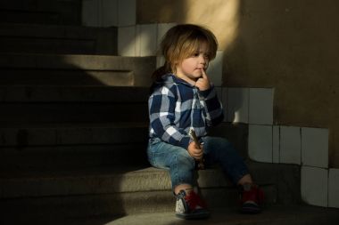 Çocuğun düşünme suratla eve merdivenlerde otur