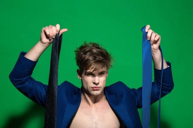 Maço mavi ceketli yeşil arka plan üzerinde gömleksiz kravat seçmek