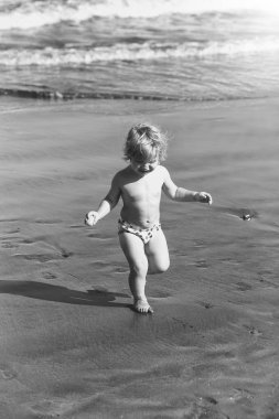 Islak kum deniz boyunca şirin neşeli bebek çocuk ishal