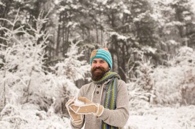 Sakallı adam gülümseme ile kartopu karlı ormandaki