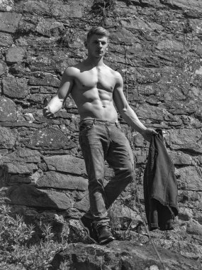 Adam çıplak göğüslü genç seksi kot duvar arka plan üzerine açık modelinde poz