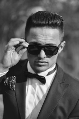 Yakışıklı genç Damat Düğün uygun papyon ile güneş gözlüğü güneşli bir günde açık