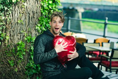 Kırmızı kalp balon ile şaşırmış adam