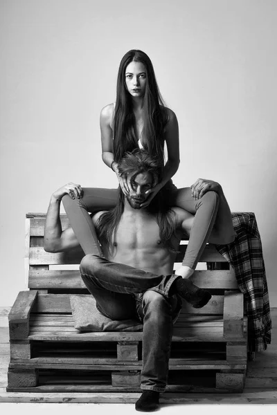 Молодая пара на деревянном диване — стоковое фото