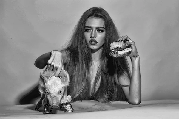 Dziewczynka jedzenie hamburgera z świnia — Zdjęcie stockowe