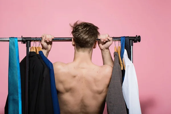 Sportsman dra upp motion på rack i garderob — Stockfoto