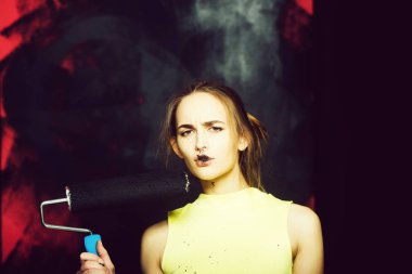 oldukça ciddi kadın ressam veya bina aracı tablo pembe duvar siyah renkte sarı yelek ile kirli sevimli seksi kız Oluşturucu-makara ile. Onarım ve inşaat kavramı