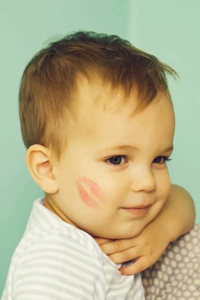 水色の壁に笑顔かわいい赤ちゃん金髪の少年子供の頬に かわいい赤いキス トレース児 — ストック写真