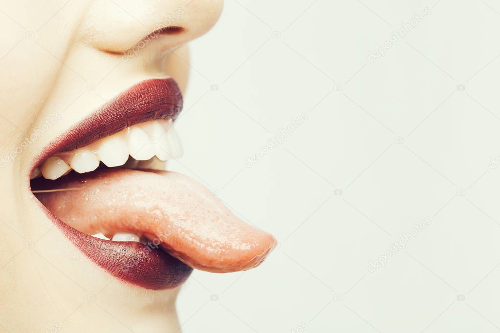 Female open smiling mouth with sexy lips purple lipstick and tongue, copy space