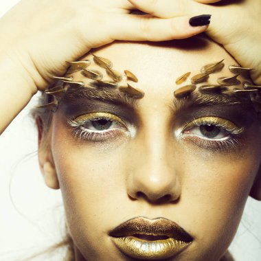 Tek bir güzel seksi vahşi genç kadınla dikenler yüz Studio beyaz arka planda, kare resim parlak altın hayvan makyajla closeup portresi