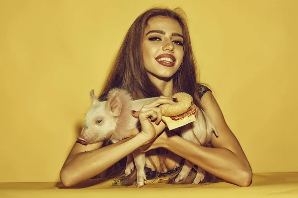 Woman with burger and pigglet — Stock Photo, Image