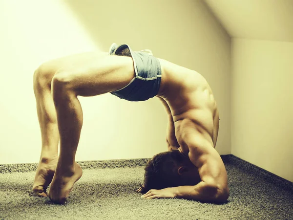 Muscular yoga man in bridge position