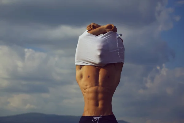 Sexy muscolare uomo spogliarsi su cielo sfondo — Foto Stock