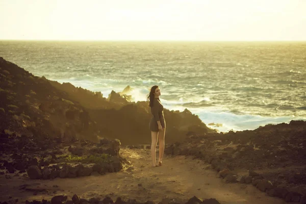 Csinos lány áll a sziklás strandtól — Stock Fotó