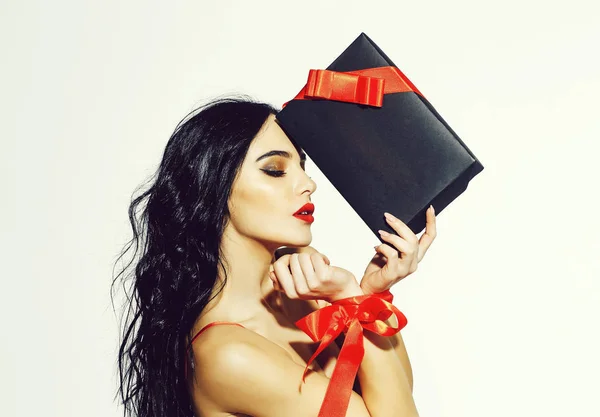Femme sexy avec des lèvres rouges, cheveux longs tient boîte cadeau — Photo