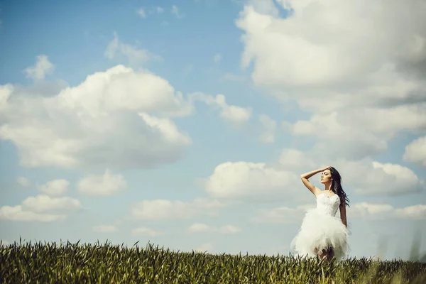 Bonita chica de la boda en hierba verde y el cielo —  Fotos de Stock