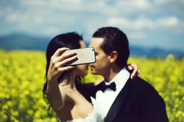 Matrimonio bacio coppia in campo fiori gialli — Foto Stock