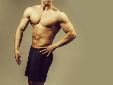 genç yakışıklı maço adam vücut geliştirmeci çıplak gövde ile seksi kaslı atletik vücut ve güçlü karın altı paketleri veya abs Studio gri arka planda, kopya alanı ile
