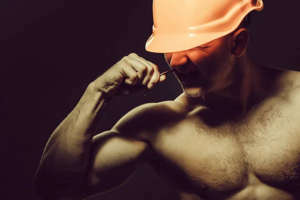 年轻英俊的男子气概男人生成器与性感肌肉运动强壮的身体赤裸的胸膛和强有力的手在橙色安全帽或头盔的穗状花序或螺柱搁置黑色背景 — 图库照片