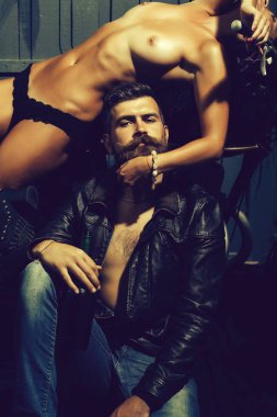 yakışıklı sakallı adam hipster motorcu sakal ve bıyık deri ceket ve çıplak seksi kadın veya kız çıplak vücut bacak ve kalça motosiklet üzerinde ahşap arka plan ile genç Çift
