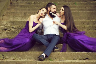 çiçeklerle karahindiba sakal taşlı merdiven güneşli açık mor elbise iki genç güzel kadınlarla Beyaz tişörtlü yakışıklı adam