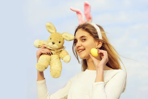 Gelukkig Pasen meisje met bunny oren, ei op blauwe hemel — Stockfoto