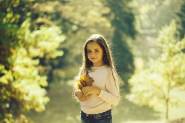 Birçok sarı yapraklar sonbahar ormanda poz onun elinde tutan güzel güler yüz ile varoluş esmer güzel kız