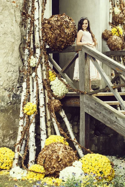 Chica sonriente en las escaleras con decoración floral —  Fotos de Stock