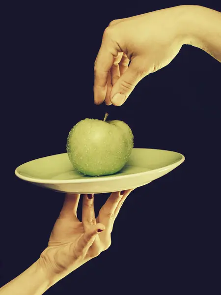 Groene appel op plaat in de hand — Stockfoto
