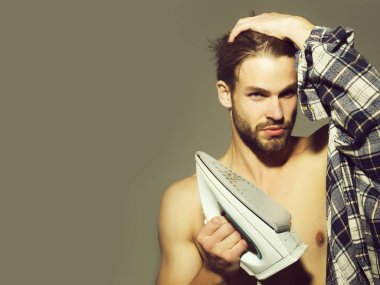 Seksi genç yakışıklı çıplak adam kısmen ekose gömlek giyer, saçları dokunur ve beyaz demir gri arka plan üzerinde kopya alanı tutar