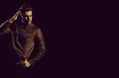 Yakışıklı adam veya şık saç kesimi, saç, moda, kahverengi, deri ceketle poz, siyah arka plan, kopya alanı üzerinde rahat kıyafet ile genç beyaz maço