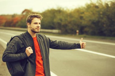 Genç adam otostop çekiyor.