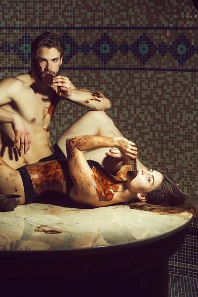 Hombre muscular y mujer sexy comer chocolate después de masaje de salón —  Fotos de Stock