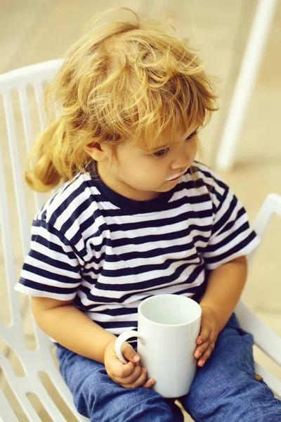 Милый Мальчик Вьющимися Светлыми Волосами Полосатой Рубашке Пьет Чашку Молока — стоковое фото