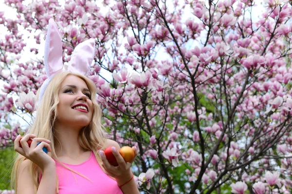 Vrouw die lacht met kleurrijke eieren met bunny oren — Stockfoto