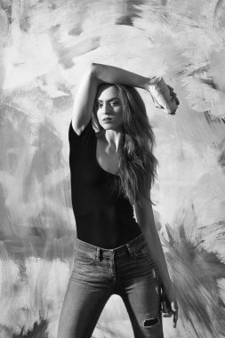 Uzun sarı saçlı kırmızı tshirt ve sprey boya şişe ile kot giyen kız ya da güzel ressam güzel veya pembe ve sarı soyut duvar grafiti için olabilir