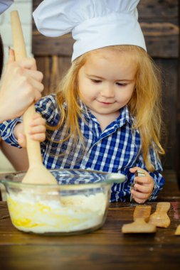 Tahta kaşıkla hamur karıştırma Şef şapkalı çocuk çocuk