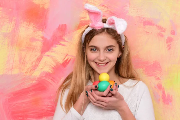 Feliz chica de Pascua en orejas de conejo con coloridos huevos pintados — Foto de Stock