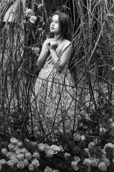 Small girl near mirror and pink flowers